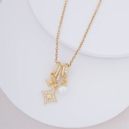 COLLAR ACERO DORADO Y SIMULACION DE DONA C/DIJES DE ESTRELLA