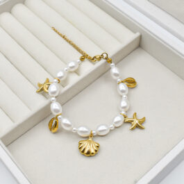 PULSERA DE ACERO DORADO CON PERLAS GRANDES Y DIJES DE MAR