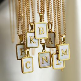 DIJE DE ACERO DORADO C/LETRA Y FONDO DE NACAR SOLO DIJE