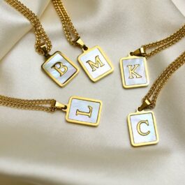 DIJE DE ACERO DORADO C/LETRA Y FONDO DE NACAR SOLO DIJE