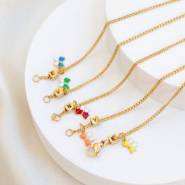 PULSERA DE ACERO DORADO C/LETRA CUBITO Y MARIPOSA ESMALTADA